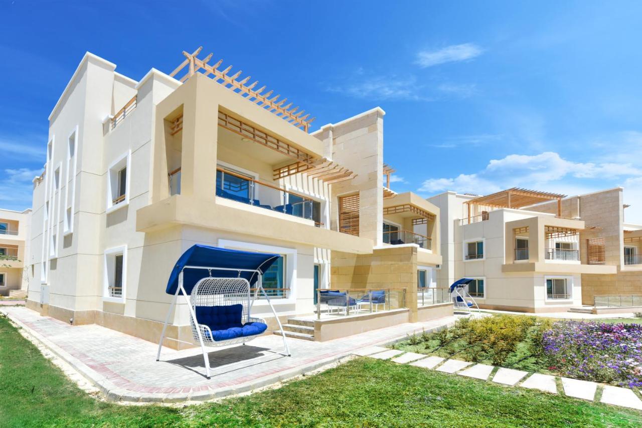 Tolip Resort El Galala Majestic Ain Sukhna Luaran gambar The photo displays a modern residential complex featuring two or more white buildings with a contemporary architectural design. Each building has balconies, large windows, and a sunshine-friendly layout that maximizes natural light. In the foreground